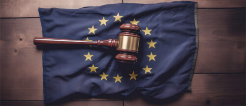 Ein Richterhammer liegt auf einer EU-Flagge, symbolisierend die Verabschiedung der KI-Gesetzgebung durch die Europäische Union.