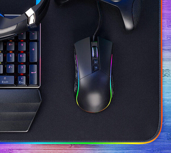 Ein Gaming-Setup mit RGB-Beleuchtung, bestehend aus einer Tastatur, Maus, Headset und LED-Streifen, das eine farbenfrohe und moderne Atmosphäre schafft.