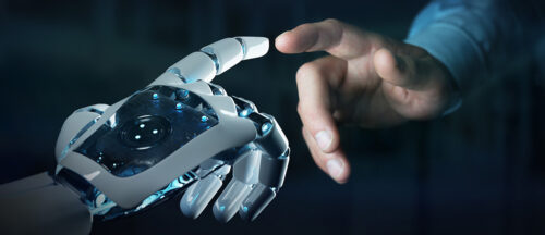 Das Bild zeigt eine menschliche Hand, die sich einer Roboterhand nähert, was die Verbindung und Interaktion zwischen Mensch und Technologie symbolisiert.